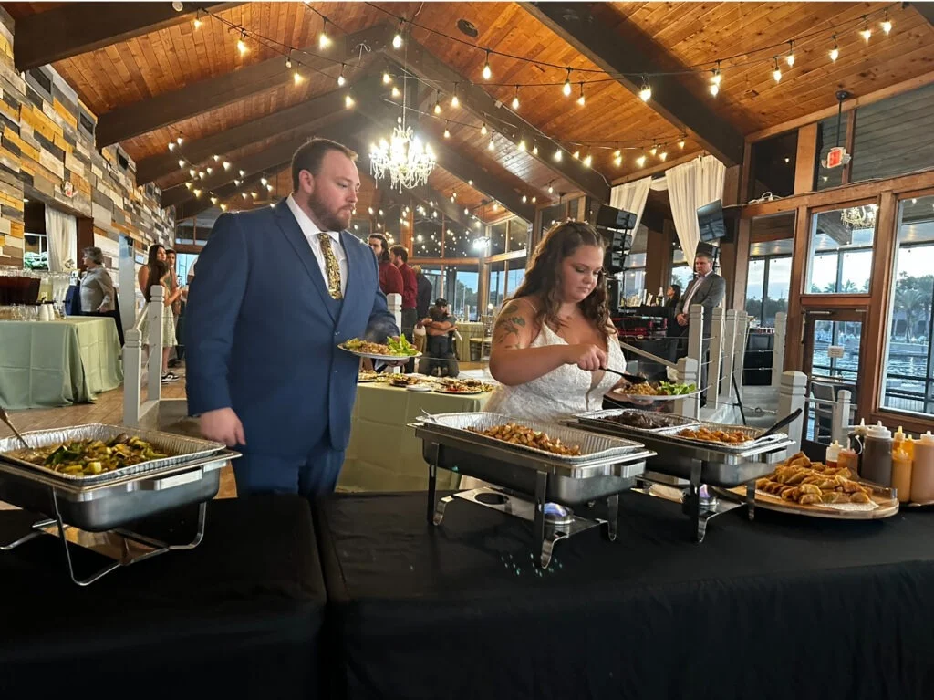 Bride and groom enjoying hibachi at their wedding reception, sharing a unique and delicious dining experience with guests.